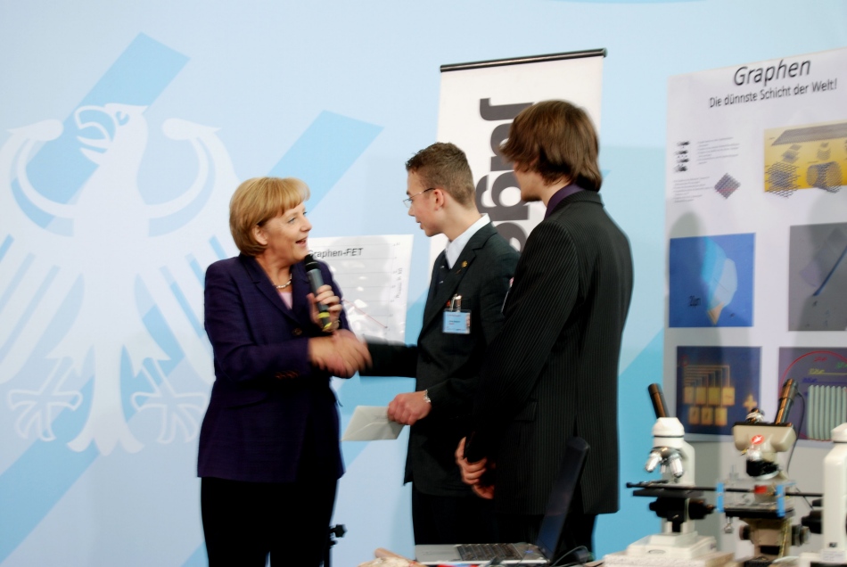 Die Bundeskanzlerin Dr. Anglea Merkel überreicht Tobias und Michael einen Scheck über 1700 Euro