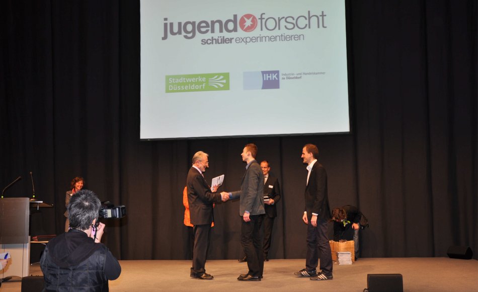 Regionalwettbewerbsleiter Rainer Linden überreicht Tobias Kaufmann und Cai-Oliver Thier die Siegerurkunde