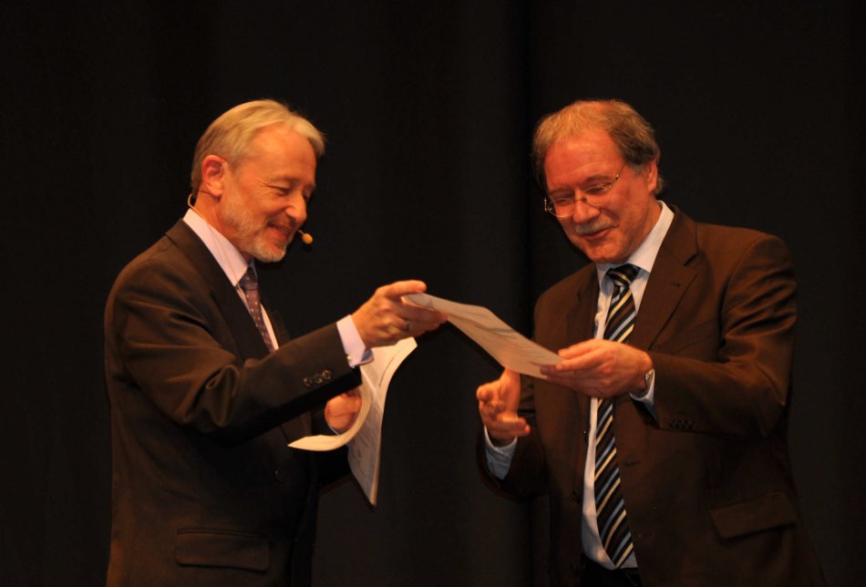 Regionalwettbewerbsleiter Rainer Linden überreicht dem sichtlich erfreuten Schulleiter Paul Georg Neft den mit 1000 € dotierten Schulpreis